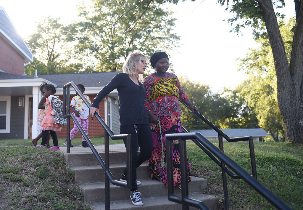 Samantha Christian, left, and Bukuru Nihabose look at the dedication ceremony for Bryant Walkway Apartments